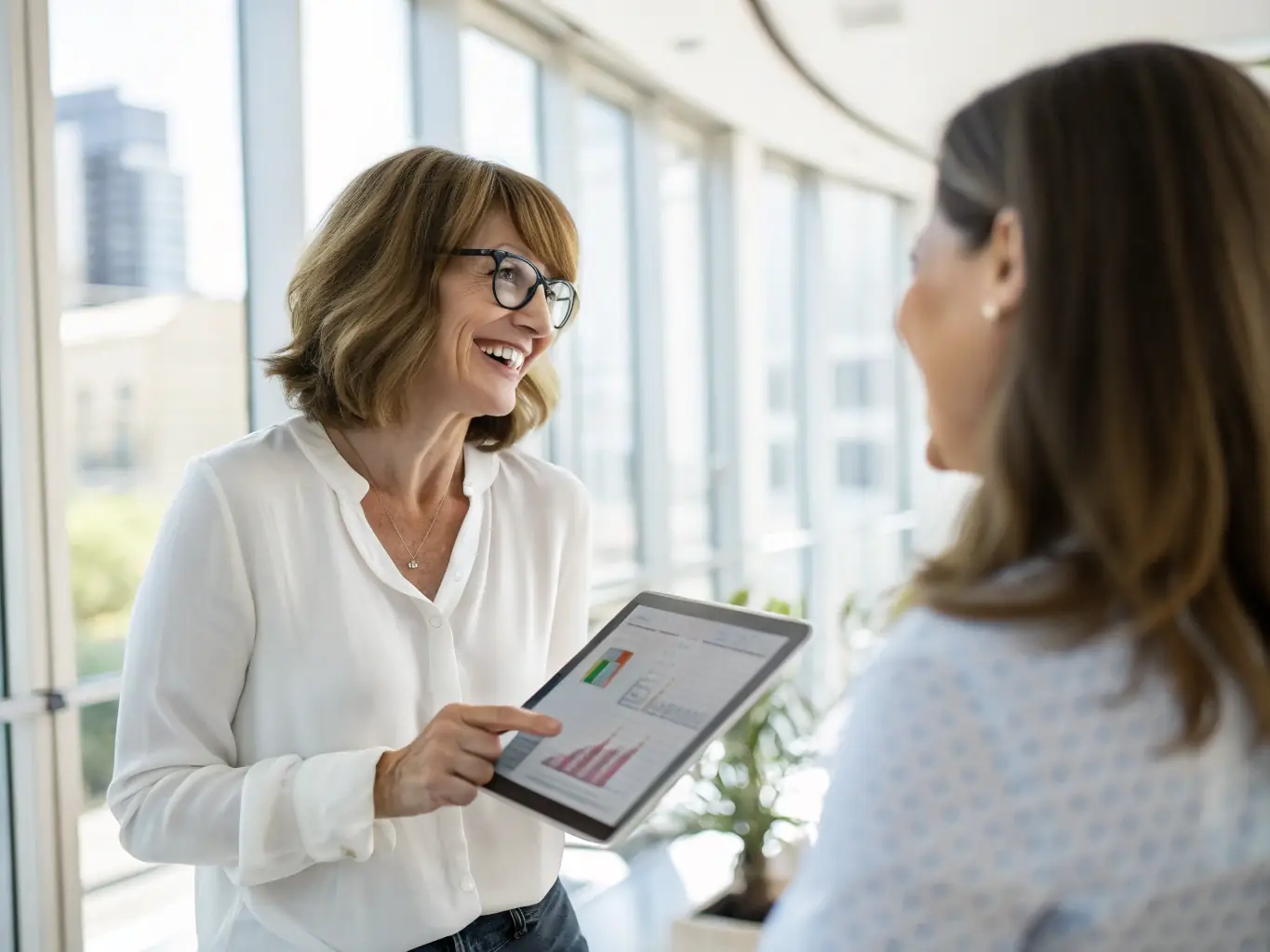 A consultant advising a small business owner on digital strategies, using a tablet to illustrate key points and data-driven insights.